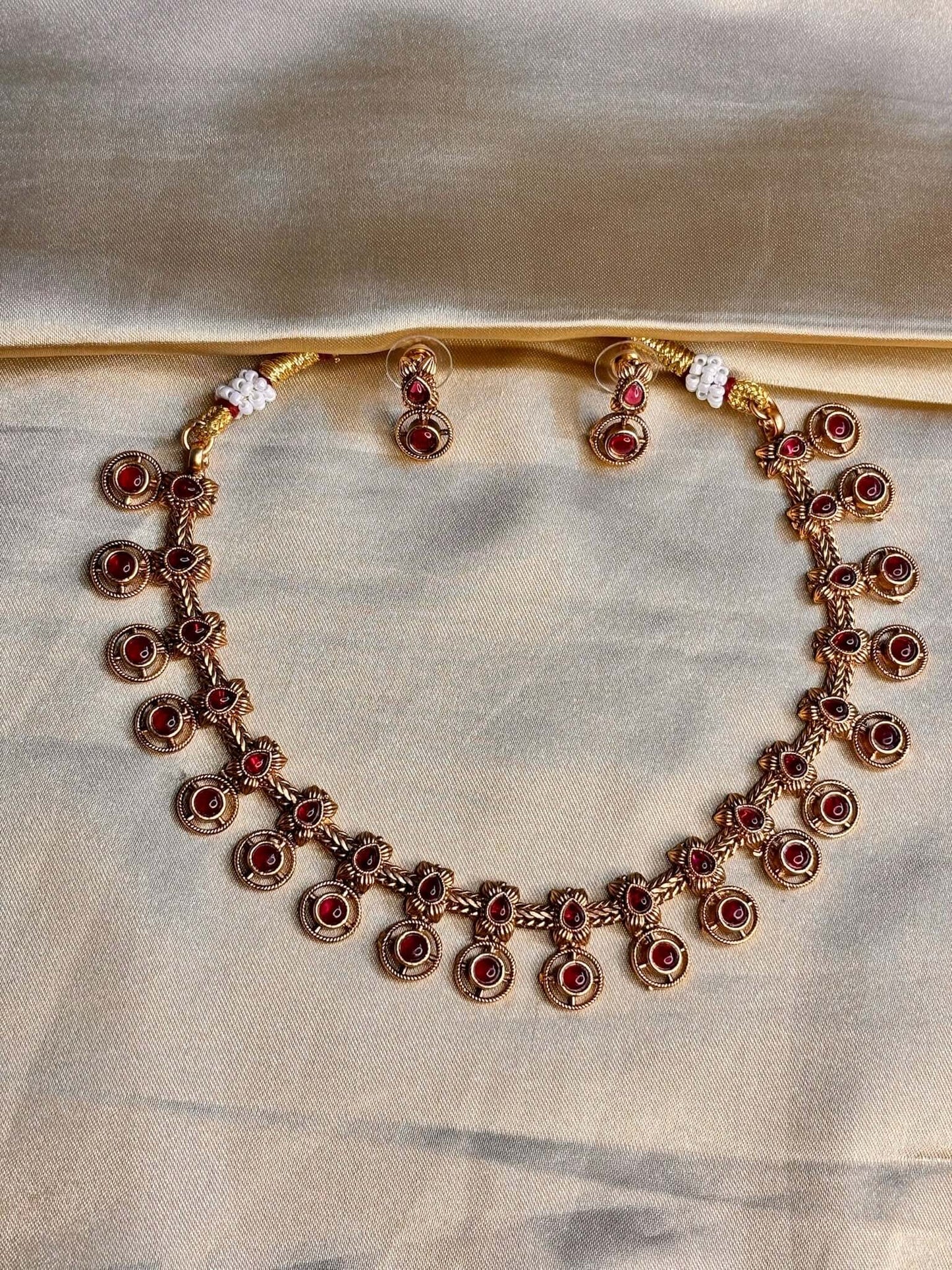 Antique circular ruby pattern necklace set with matching earrings, showcasing vintage elegance in imitation jewelry.