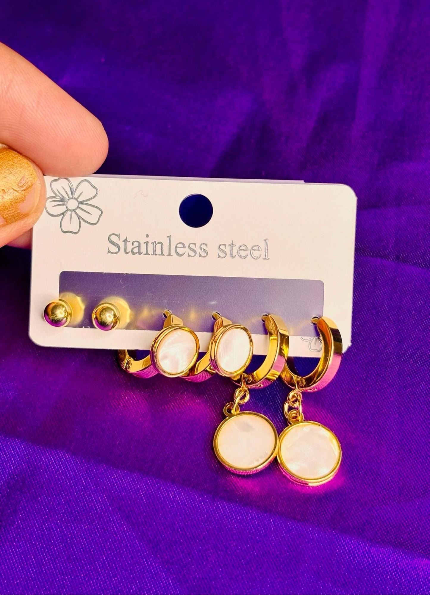 Elegant pearl-finish stainless steel earring set showcasing gold-toned studs and oval hoops, ideal imitation jewelry.