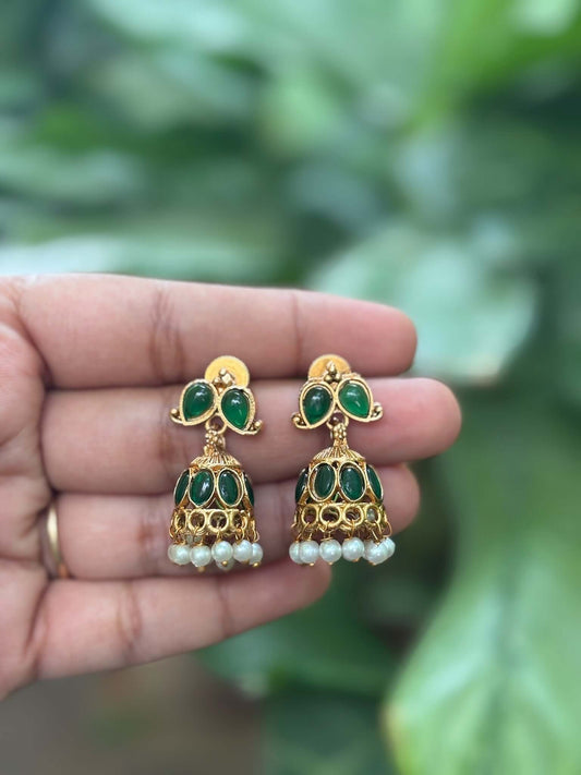 Green stone jhumka earrings with pearl drops and antique gold finish